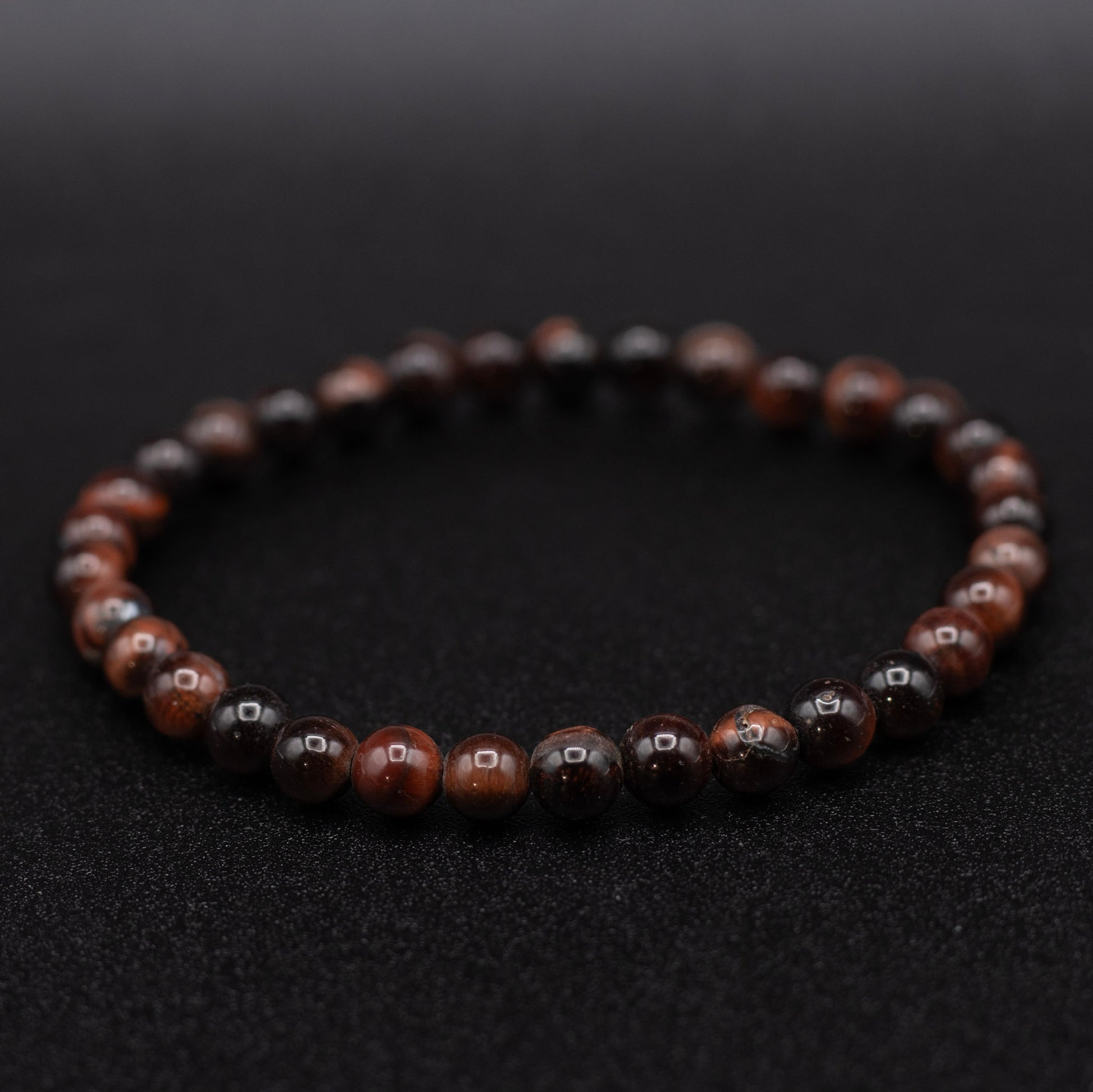 Beaded bracelet with brown and black beads on a dark background