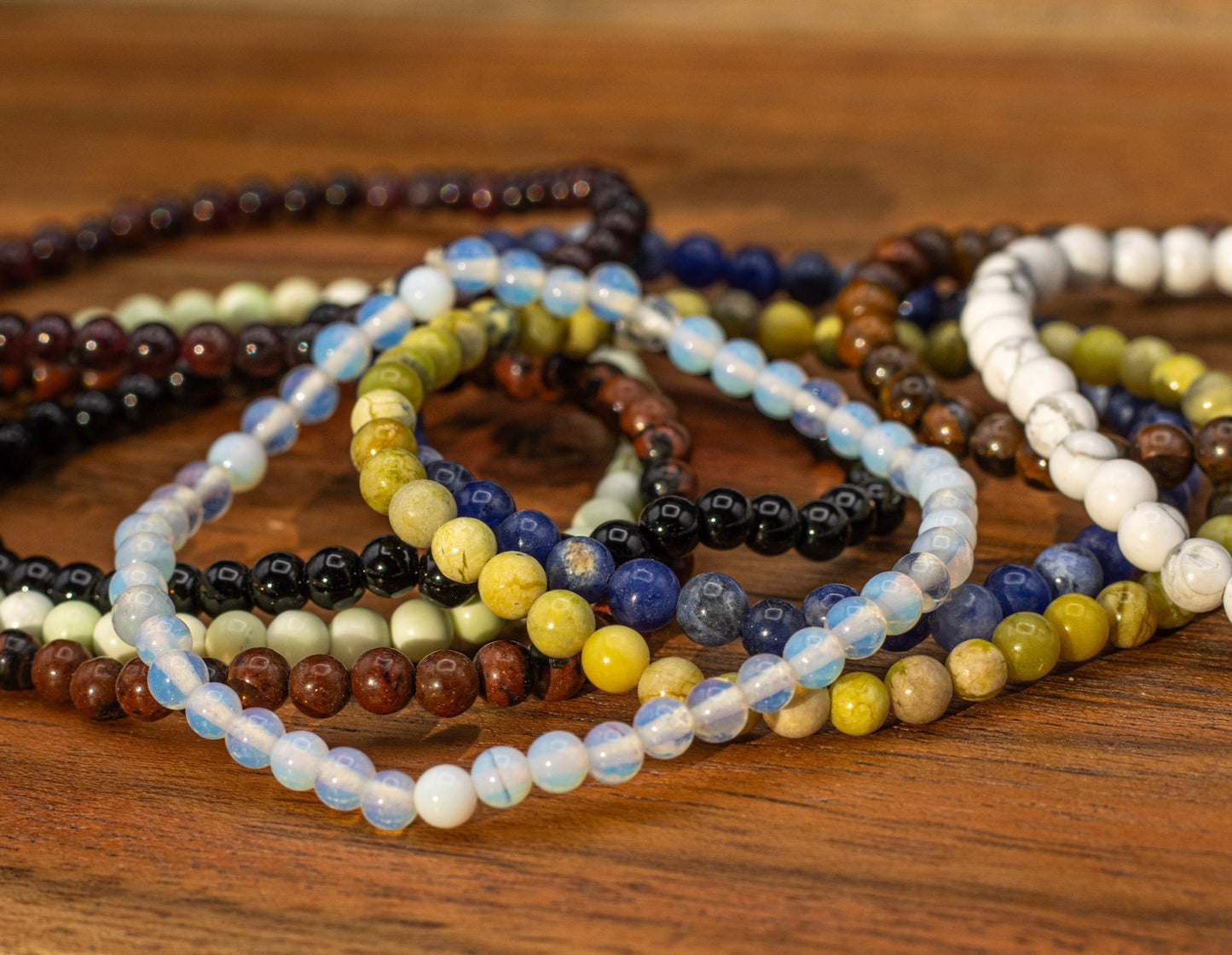 Stack of beaded bracelets on a wooden surface