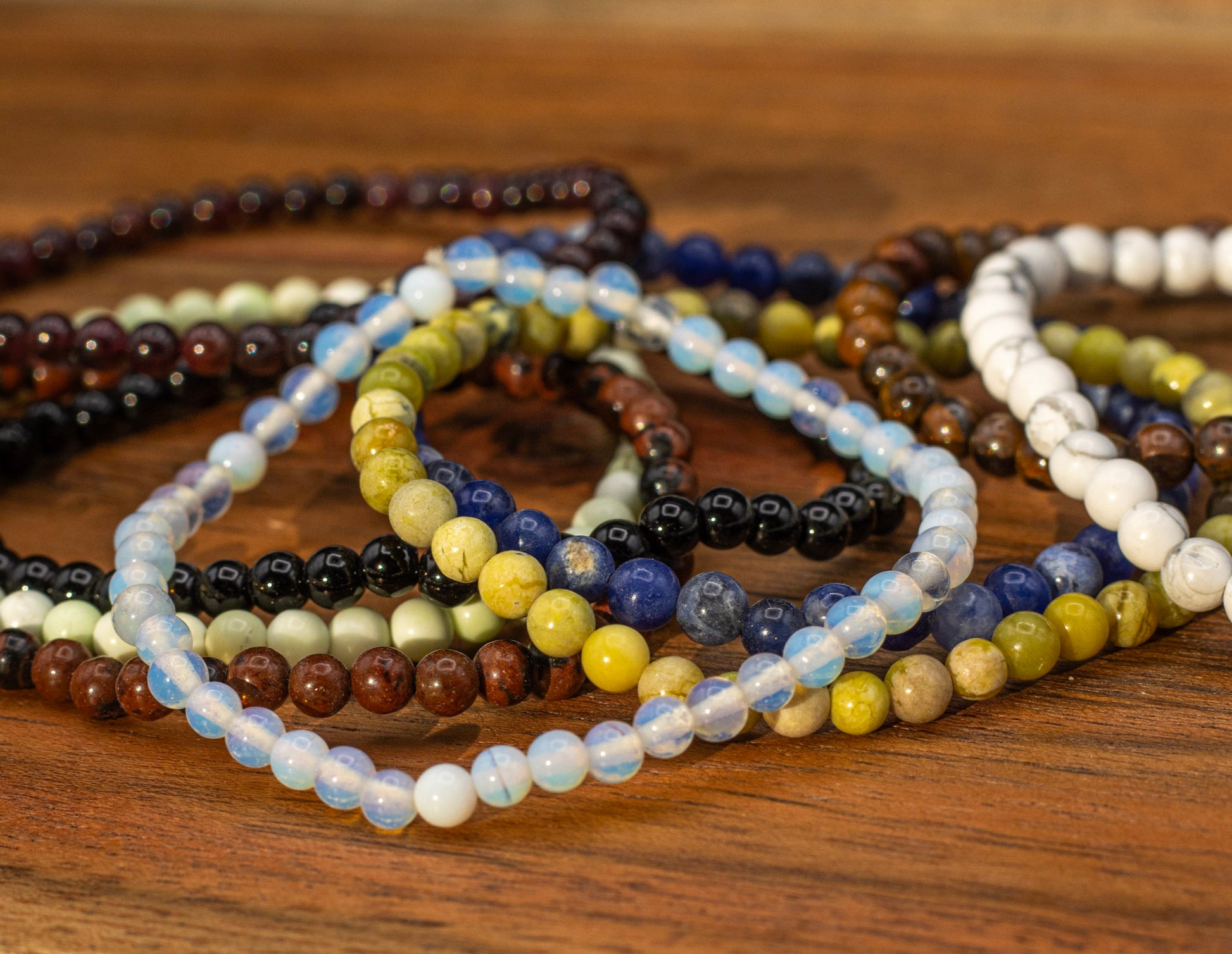 Stack of beaded bracelets on a wooden surface