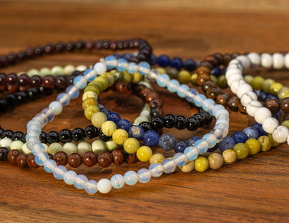 Stack of beaded bracelets on a wooden surface