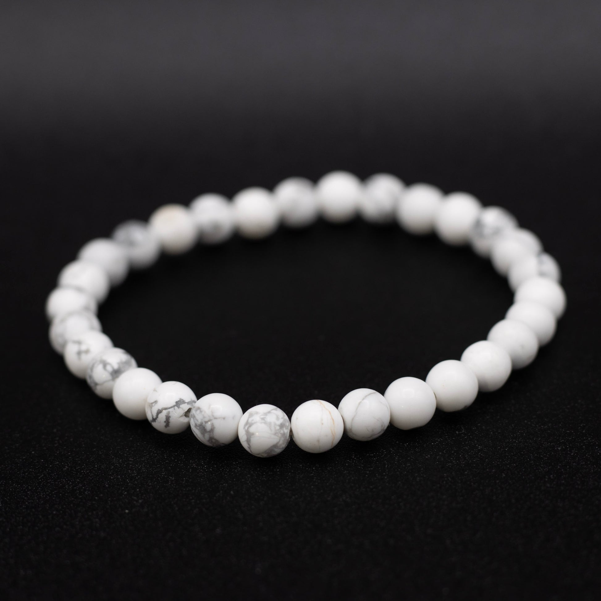White beaded bracelet on a black background
