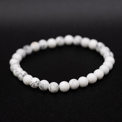 White beaded bracelet on a black background