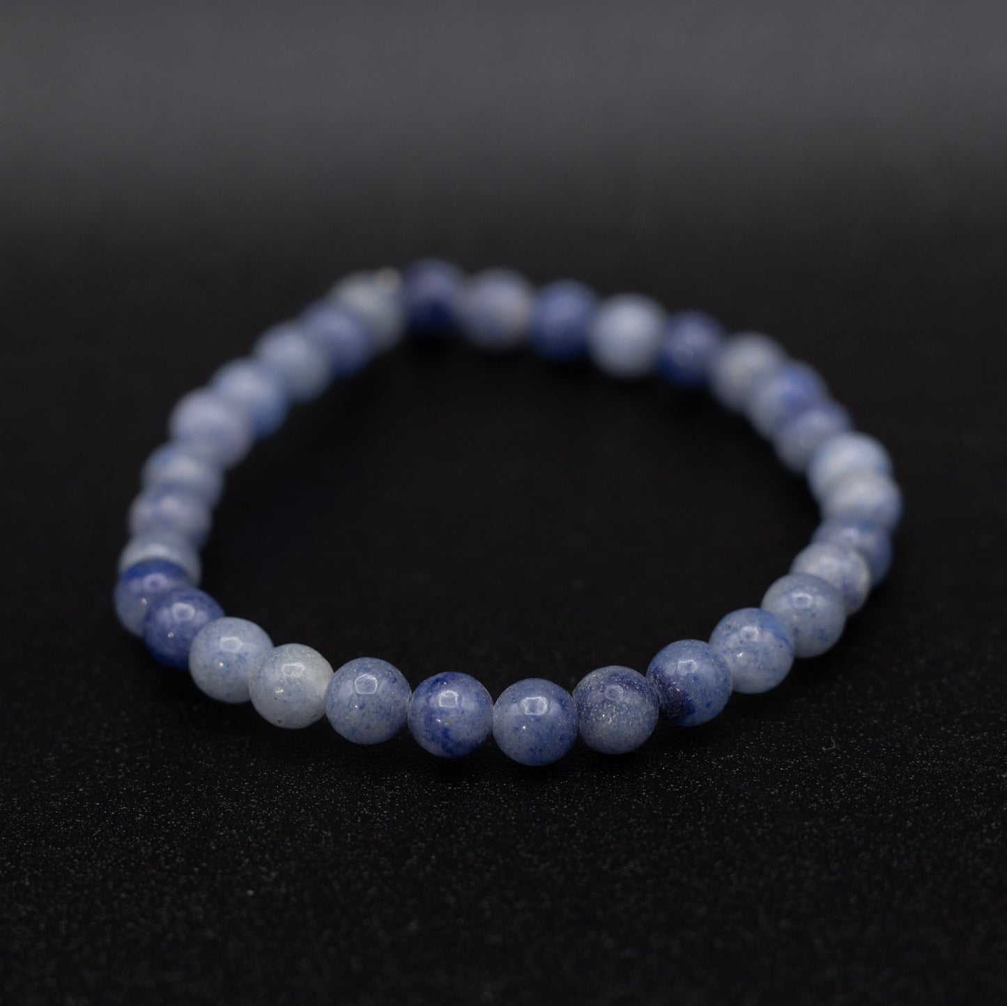 Beaded bracelet with blue and white stones on a black background
