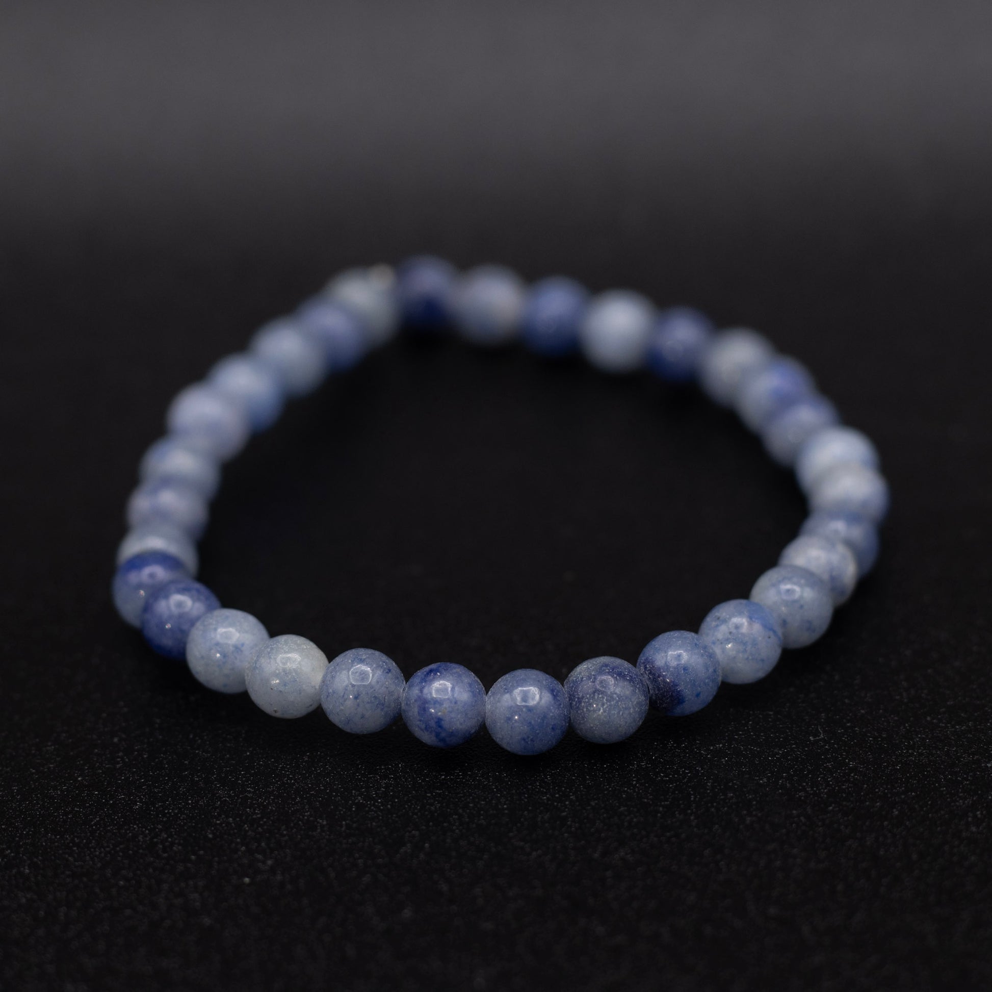 Beaded bracelet with blue and white stones on a black background